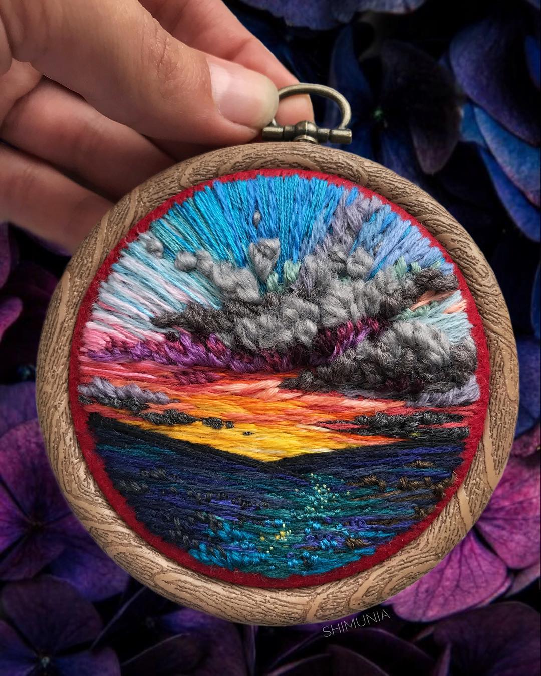 A stunning embroidered sunset with clouds and a vibrantly-colored sunset.