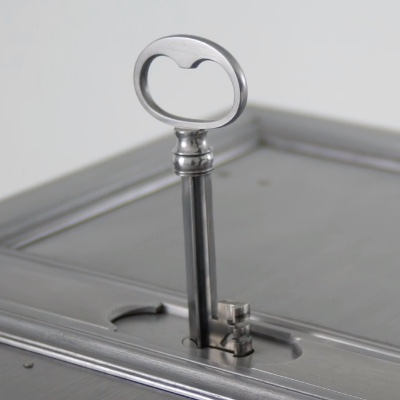 A beautiful metal lockbox with a large key inserted into the lid.